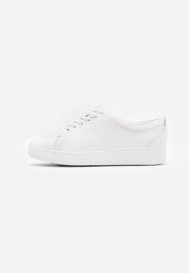 White leather sneaker with a rounded toe, lace-up design, and flat rubber sole. Smooth texture and minimalistic detailing on sides.