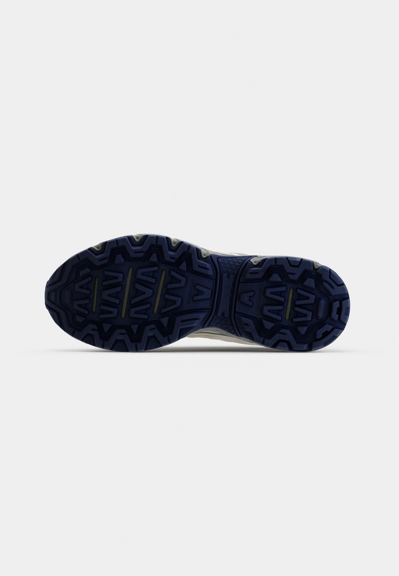 Suela de zapato de goma azul oscura con un patrón de zigzag texturizado, bordes reforzados y ranuras centrales para tracción.
