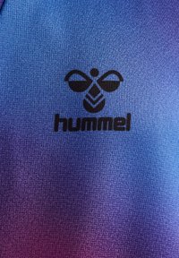 Blå och lila gradienttyg med ett texturerat mönster, med en framträdande svart logotyp som läser "hummel" och en stiliserad grafik ovanför.