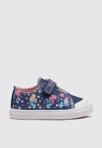 Zapatillas de mezclilla azul con una correa de velcro, que presentan coloridos patrones de unicornios y estrellas, forro rosa y una suela blanca con acentos en forma de corazón.