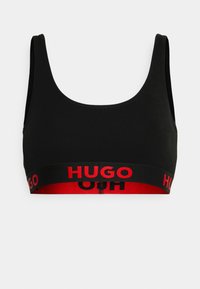 Zwarte crop top beha met een ronde halslijn en brede schouderbanden, met een rode band waarop "HUGO" in vetgedrukte zwarte letters staat.