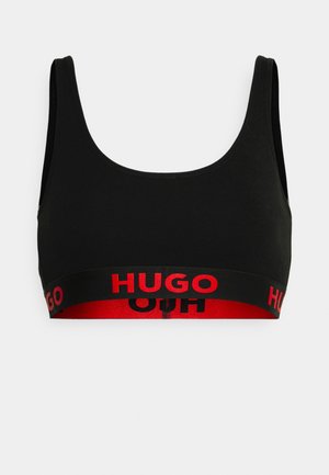 Zwarte crop top beha met een ronde halslijn en brede schouderbanden, met een rode band waarop "HUGO" in vetgedrukte zwarte letters staat.