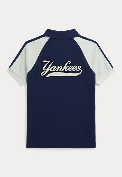 Tamsiai mėlynas ir baltas trumpomis rankovėmis polo marškinėliai su baltu užrašu "Yankees" siuvinėtu ant nugaros.