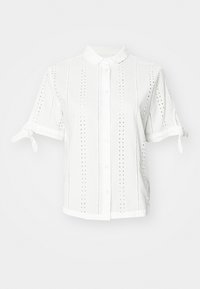 Chemise blanche à manches courtes avec fermeture par boutons, ornée de motifs à œillets, col et manches à nouer. Fabriquée en tissu léger.