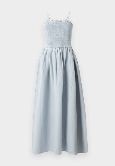 Lichtblauwe, lange katoenen jurk met een smocked bodice, dunne schouderbandjes en een vloeiende, geplooide rok. Bevat een rimpelige bovenrand.