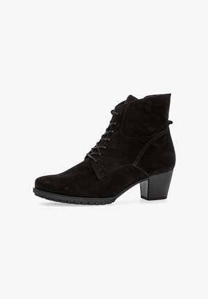 Schwarze Wildleder-Ankle-Boots mit glatter Oberfläche, Schnürung an der Vorderseite und Blockabsatz. Mit leicht spitz zulaufender Zehenpartie und strukturiertem Sohle.