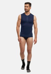 Granatowy bezrękawnik o dopasowanym kroju, wykonany z elastycznej tkaniny. Posiada minimalistyczne logo na klatce piersiowej oraz miękką, gładką teksturę.