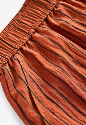 Kangas ruskovärinen tummansinisin pystyraitoihin, jossa on kerätty elastinen vyötärönauha ja tekstuuripinta, jolla on ryppyinen ulkonäkö.