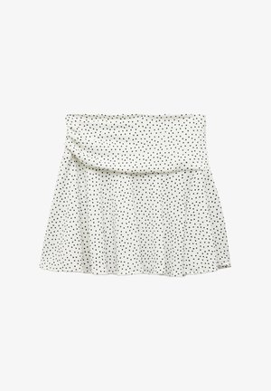 Hvid nederdel med sorte prikker, med en indsamlet talje og en udvidet kant. Lavet af blødt stof, har den en glat tekstur.