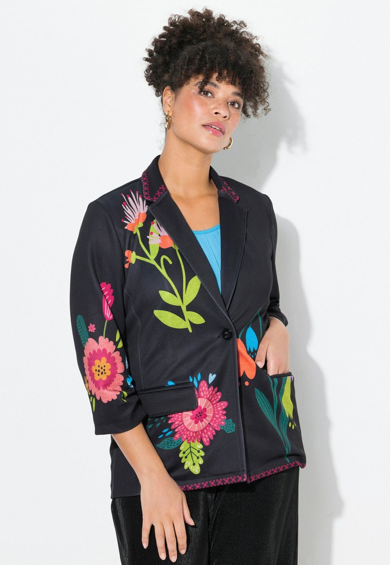 Schwarze Blazerjacke mit lebendiger floralem Stickerei in Pink, Grün und Blau. Verfügt über einen einzelnen Knopf, einen strukturierten Kragen und zwei Seiten Taschen.