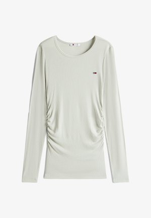 Jasnozielona bluzka z długim rękawem o teksturowanej prążkowanej tkaninie. Posiada zaszewki po bokach oraz małe logo na klatce piersiowej. Okrągły dekolt.