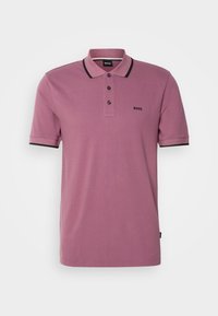 Lila pikétröja med krage, treknappsstängning, svarta detaljer på ärmarna och subtil logotyp på bröstet. Tillverkad av bomull.