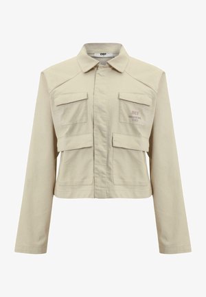 Beige cropped jacket made of cotton with long sleeves, two front pockets, and a subtle logo printed on the left chest. Smooth texture.