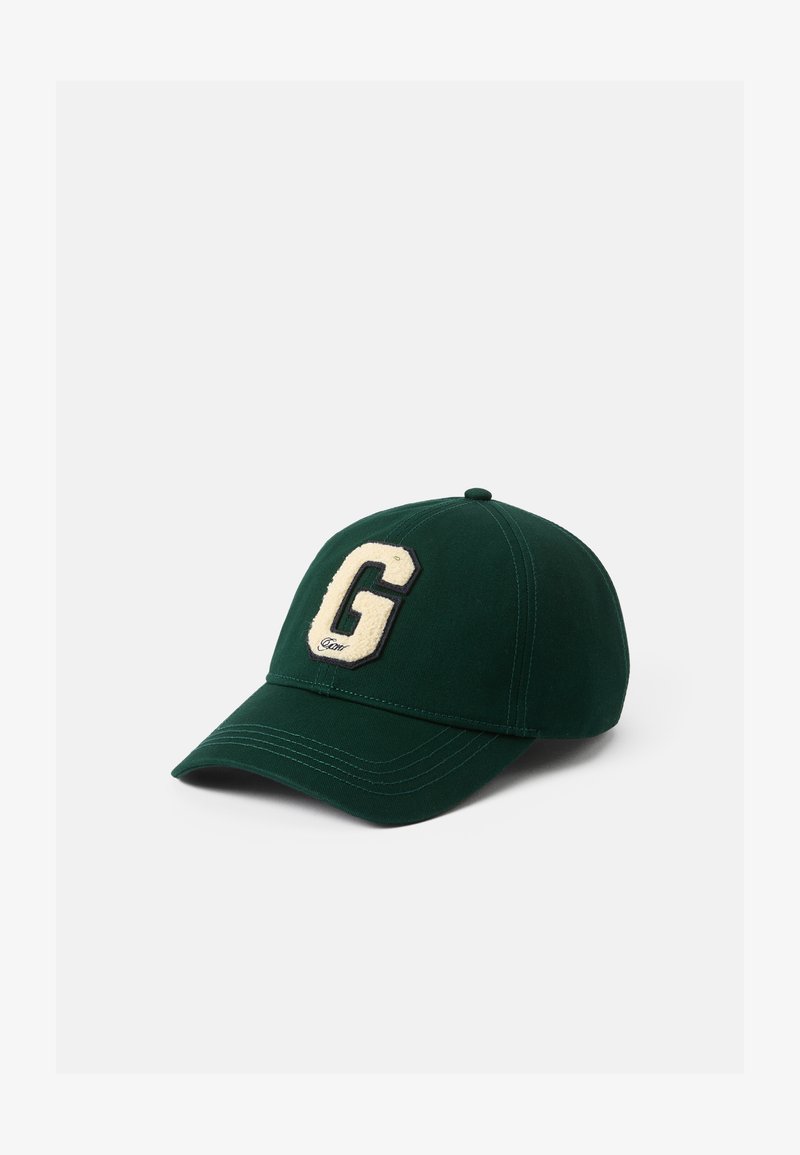 Grøn baseballkasket lavet af stof, med et forhøjet cremefarvet "G" logo på forsiden, en buet skygge og syede detaljer.