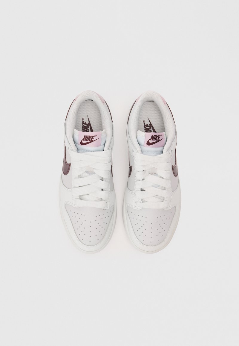 Witte leren sneakers met roze en bordeauxrode accenten, geperforeerde neus, platte witte veters en een gelabelde tong.