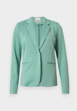 Blazer vert menthe avec une fermeture à un bouton, revers crantés, deux poches avant et une texture lisse. Étiquette de la marque visible à l'intérieur du col.