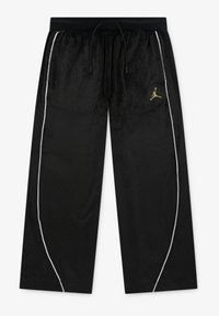 Crne baršunaste trenerke s crnim elastičnim pojasom, bijelim bočnim trakama i zlatnim Jumpman logotipom na lijevom bedru.
