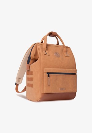 Sac à dos en cuir tan avec double poignée supérieure, bretelles réglables, poche zippée à l'avant et base texturée. Présente un patch logo.