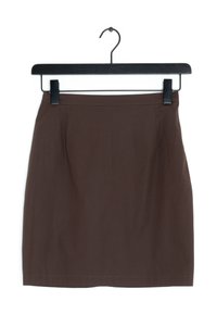 Brun kjol på en svart hängare, med en figursydd design, slät yta och rena linjer utan synliga mönster eller beslag.