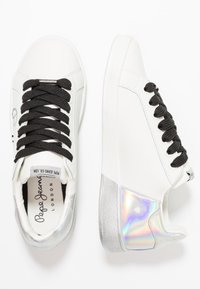 Baskets basses blanches avec lacets noirs, détail argent irisé au talon et marquage "Pepe Jeans London" sur la semelle intérieure et l’étiquette de la languette.