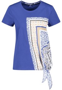 Blue short-sleeve shirt with round neck, featuring an asymmetrical geometric patterned scarf print and side knot detail on the front right.