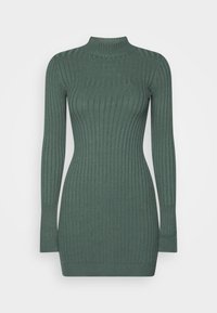 Abito maglione a coste di colore verde scuro, con collo alto, maniche lunghe e silhouette aderente. La texture è morbida ed elastica.