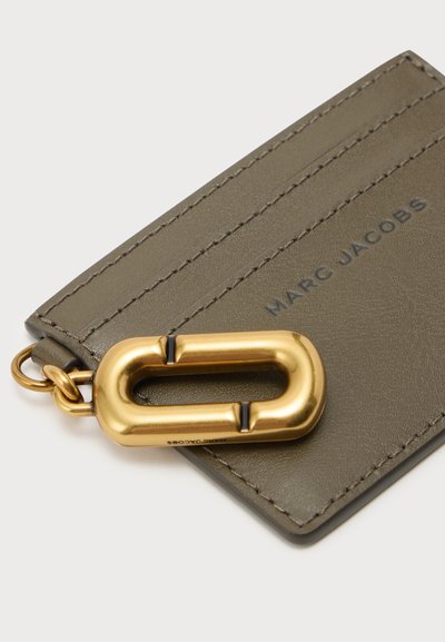 Porte-cartes en cuir vert olive avec trois emplacements pour cartes et un grand mousqueton en métal doré gravé Marc Jacobs.