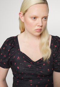Vestido preto com estampado floral, apresentando mangas curtas com volume, decote coração e pequenos padrões florais vermelhos e brancos em tecido texturizado.