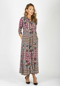 Maxi sukienka z wielokolorowym wzorem diamentów i liści w odcieniach różu, niebieskiego i brązu. Posiada długie rękawy i boczne kieszenie.