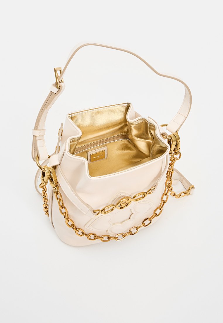 Cremfarbene Lederhandtasche mit goldener Kettenriemen, goldmetallischem Innenraum und floralem Design auf der Vorderseite, offen gezeigt auf einem weißen Hintergrund.