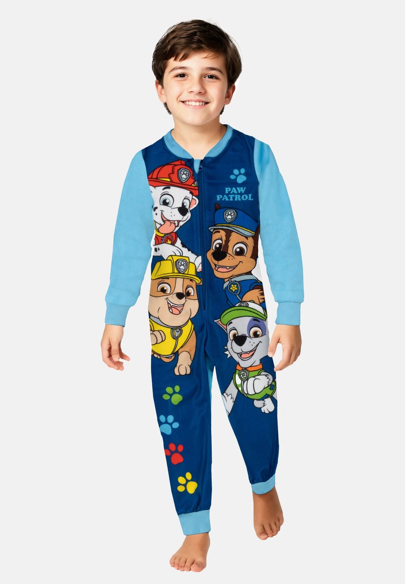 Tutina a tema Paw Patrol in tessuto blu e azzurro chiaro. Presenta cani dei cartoni animati sulla parte frontale, dettagli con impronte di zampe e una chiusura con zip.