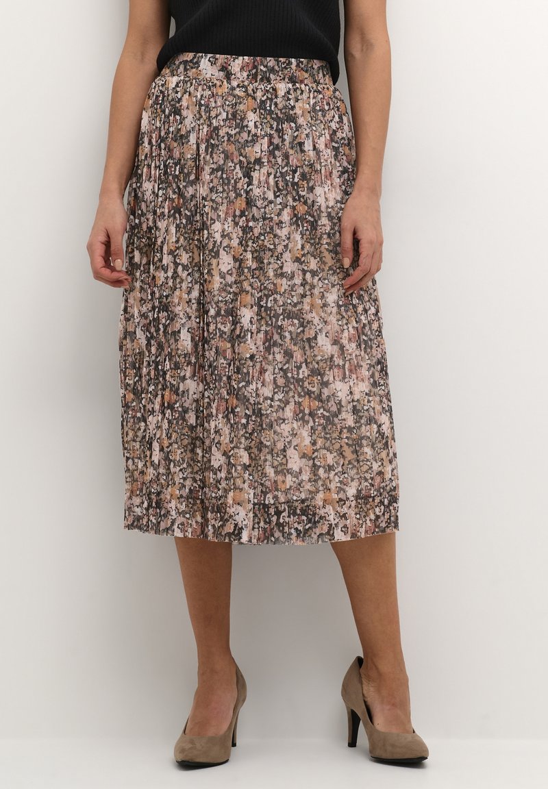 Jupe midi plissée en tissu doux avec un imprimé floral aux nuances de rose, marron et crème. Taille élastique ; portée avec des talons beiges.
