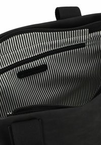 Zwarte tas met een binnenvoering en een ritsvak, en een zwart-wit gestreepte voering. Duurzaam materiaal met nette stiksels en een handvat aan de bovenkant.