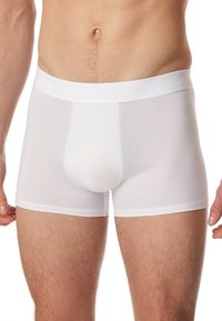 Boxer-briefs en coton blanc avec un ajustement serré. Dotés d'une taille élastique douce et d'un design de poche moulant. Texture lisse sans motifs visibles.
