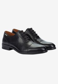 Zapatos de vestir de cuero negro con un acabado suave, punta redondeada y diseño de cordones. Presentan detalles de costura y un tacón bajo y cuadrado.