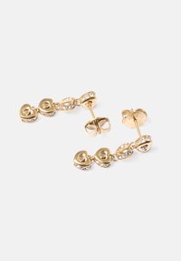 Brincos de studs em tom dourado com motivos em forma de coração e realces em strass transparente, compostos por três peças interligadas e fechos em borboleta.