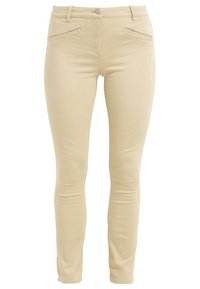 Jean skinny beige en tissu extensible en coton mélangé. Présente une taille mi-haute, deux poches avant et une silhouette de jambe lisse et ajustée.