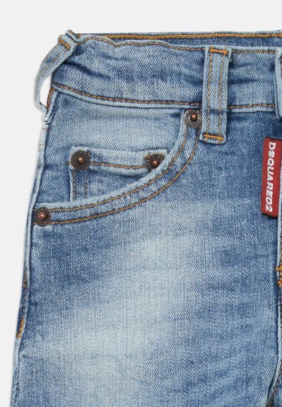 Svijetloplave traperice s izblijedjelim završetkom, bakreni zakovici na džepovima, vidljivo šivanje i crveni DSquared2 označavač na pojasu.
