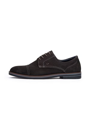 Chaussure habillée en suede brun foncé avec lacets, accents cousus, embout arrondi et semelle en caoutchouc contrastante. Design plat, style minimaliste.