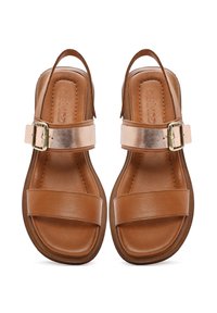 Sandali in pelle marrone con due fasce larghe, una fascia metallica e chiusura con fibbia. Suola piatta con una forma arrotondata.