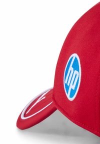 Czerwona czapka z niebieskim okrągłym logo HP i białymi akcentami. Posiada zakrzywiony daszek i teksturowany materiał dla wygody.