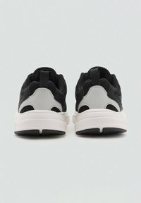 Črne in sive športne copate z mrežasto zgornjico, oblazinjenim ovratnikom in belim srednjim podplatom. Imajo zanko na peti in teksturiran gumijast podplat.