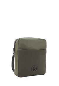 Borsa verde oliva realizzata in tessuto testurizzato, con una tasca frontale, chiusura con cerniera e un accento a logo rotondo. Design rettangolare compatto.