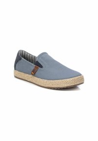 Zapato slip-on de lona azul con suela de yute, con un forro interior a rayas y una pequeña etiqueta de acento marrón en el costado.