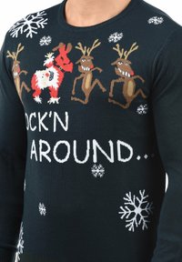 Pull bleu marine avec rennes dansants et Père Noël, flocons de neige blancs, et le texte "ROCK'N AROUND" en lettres blanches sur la poitrine.