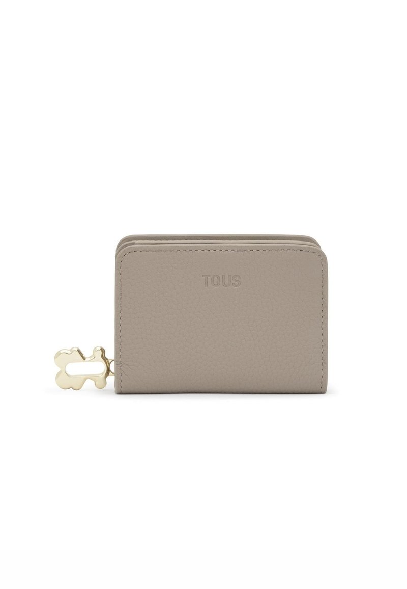 Cartera de cuero beige con acabado texturizado, que presenta un tirador de cremallera con forma de oso en tono dorado y el logo "TOUS" en relieve.