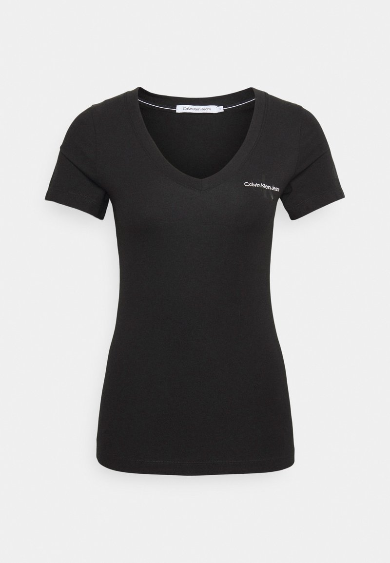 Svart kortärmad t-shirt med v-ringning. Har Calvin Klein Jeans-logotypen i vitt på vänster bröst. Slätt bomullstyg.