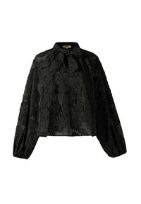 Blouse noire texturée avec motif floral, manches longues bouffantes et un nœud à la base du col. Le tissu semble léger et superposé.