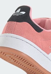 Rosa Wildleder-Sneaker mit einem schwarzen Wildleder-Fersenlasche, weißer strukturiertem Zwischensohle und Gummi-Außensohle. Verfügt über ein Drei-Streifen-Logo an der Ferse.