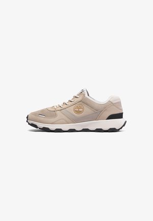 Beige Sport Schuhe mit einem strukturierten Wildleder-Obermaterial, weißen Akzenten, schwarz-gummierter Sohle und einem runden Logo an der Seite.